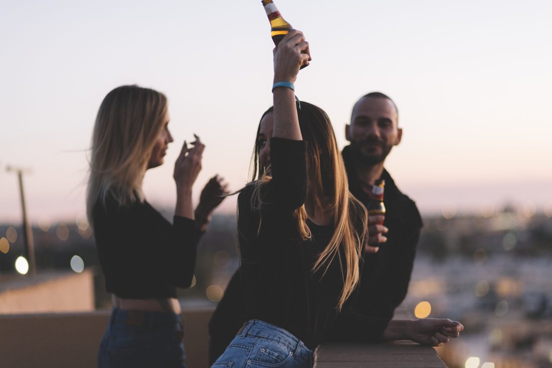 Des amis lèvent leur verre au coucher du soleil